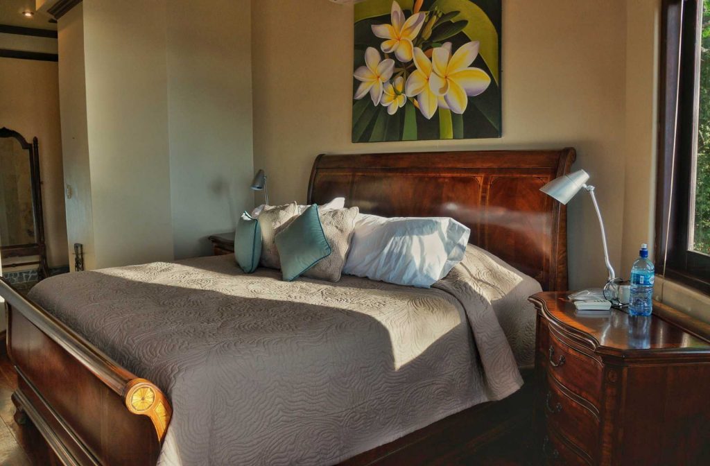 This master bedroom features a queen sleigh bed and beautiful artwork. 