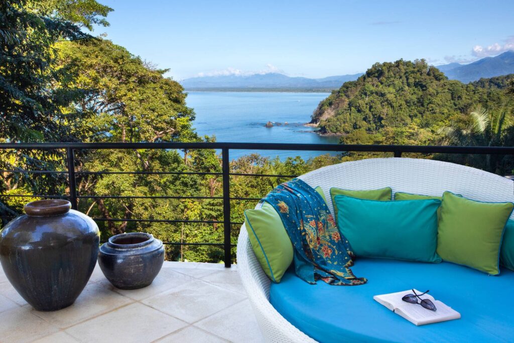A comfortable ocean-facing sitting area where rainforest greenery and coastal views create a calm setting for slow mornings.