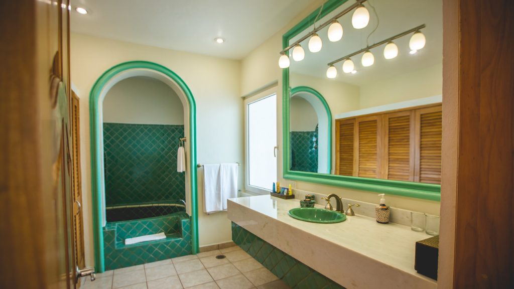 This particular bathroom is uniquely designed with green accents in the tiles and trim.  