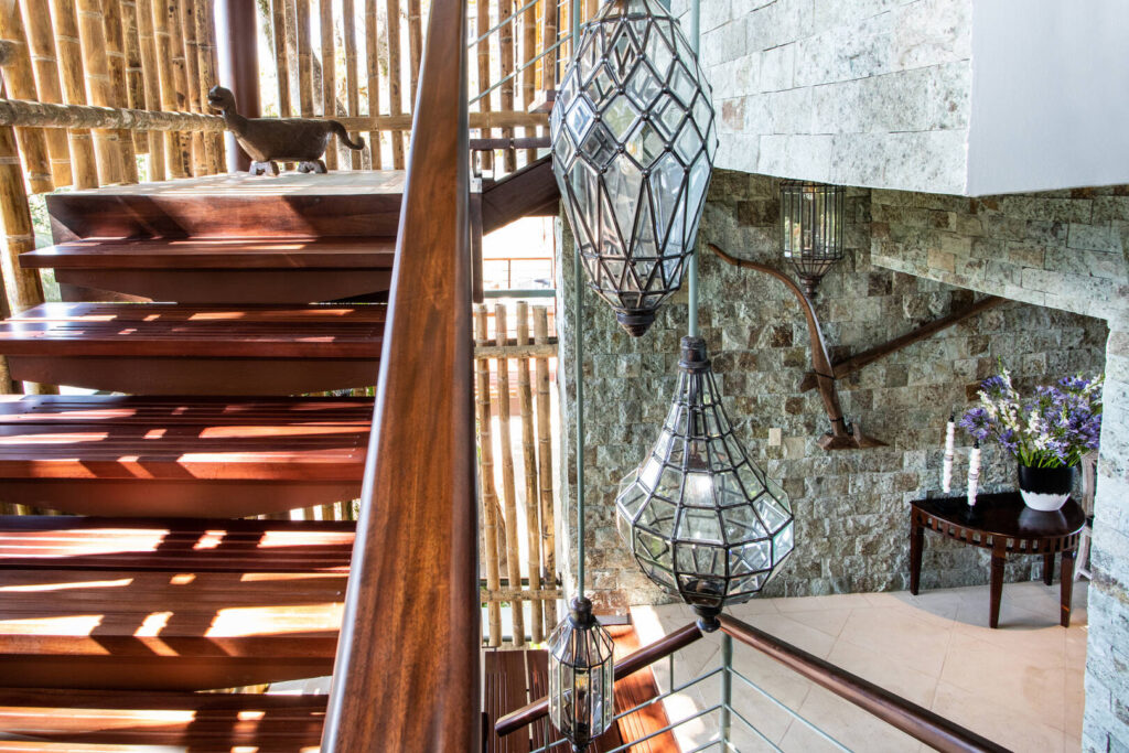 Natural light pours through this striking staircase, where sculptural lighting, warm wood, and stone textures create a memorable architectural moment.