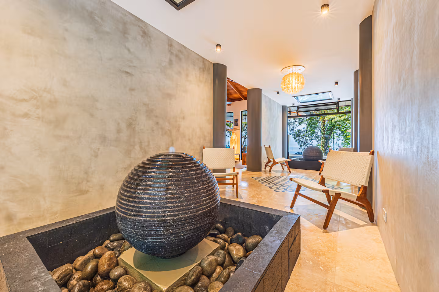 Open living and dining area with seating, dining table, and jungle views in a luxury villa near Dominical, Costa Rica.