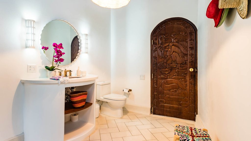 Each bathroom is unique including this one with nice accents and a carved wood door.