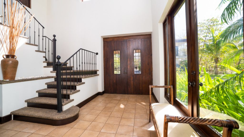 A large foyer with stairs to the side and a seating area.
