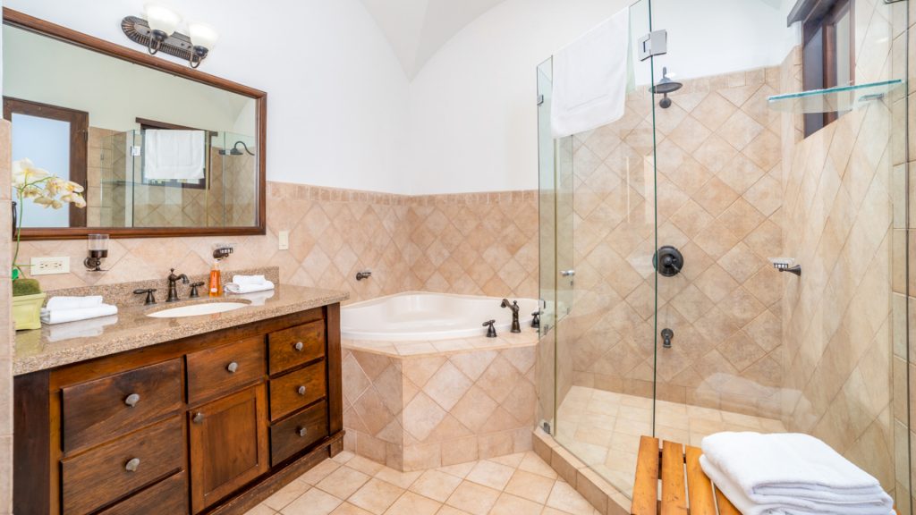 This extra large bathroom also features a big mirror and glass wall shower.