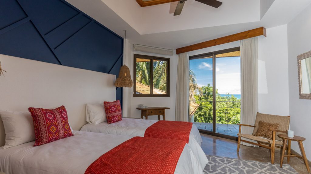 This colorful bedroom for younger guests has two twin beds and an ocean-view balcony.