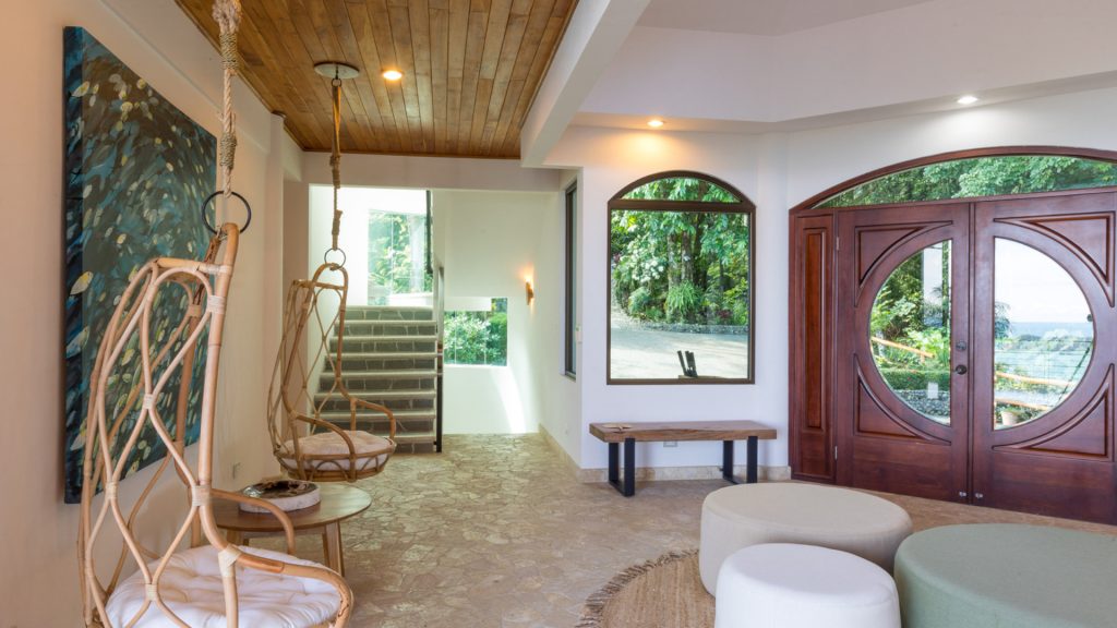 The beautiful entrance to the villa has a natural stone floor, some awesome art, and unique seating.