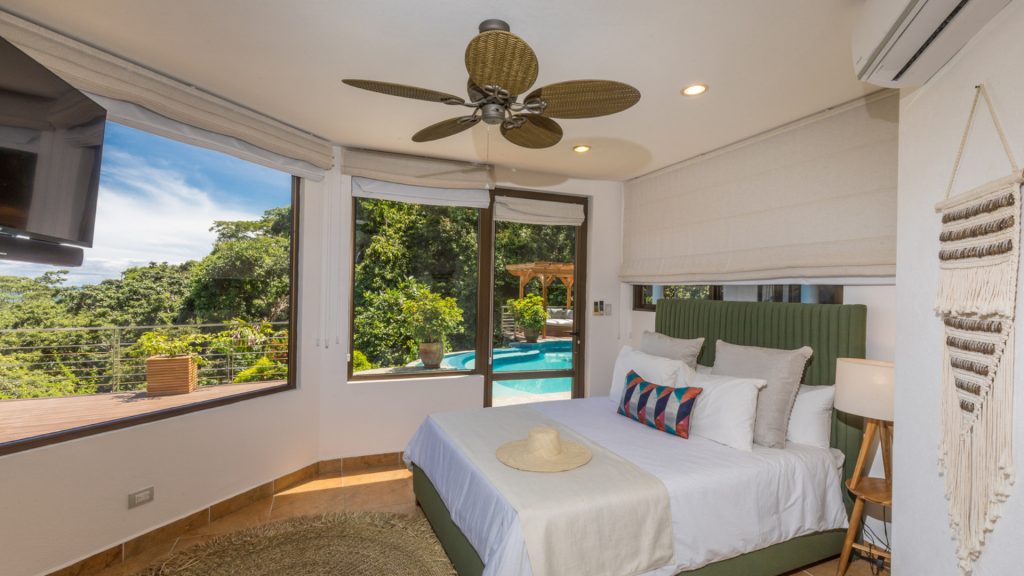 This bedroom has entertainment via the pool, the TV, and the panoramic ocean view.