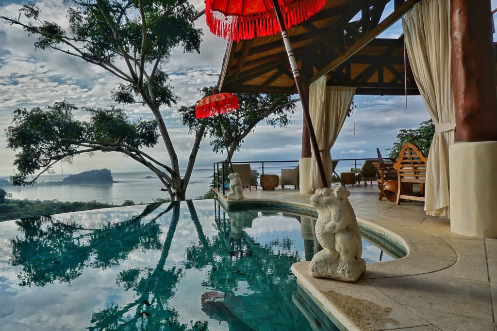The infinity pool with its stone-tiled steps is reminiscent of a Roman bath with tropical frog statues as umbrella stands. 