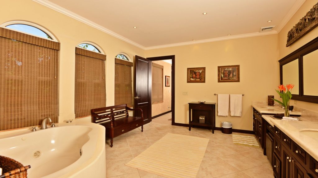 This spacious ensuite bathroom has a huge soaking jacuzzi tub and his and hers sinks.