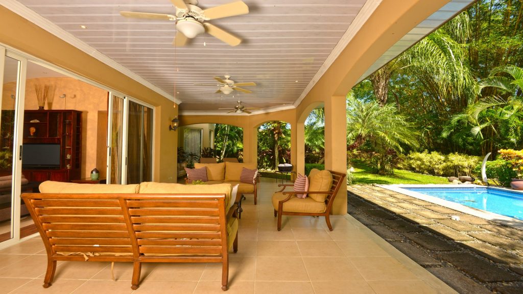 Relax with family by the pool on this spacious veranda with ceiling fans.
