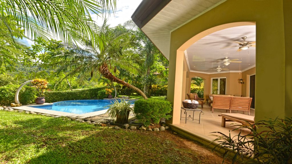 Well-maintained gardens and tropical plants surround the pool.