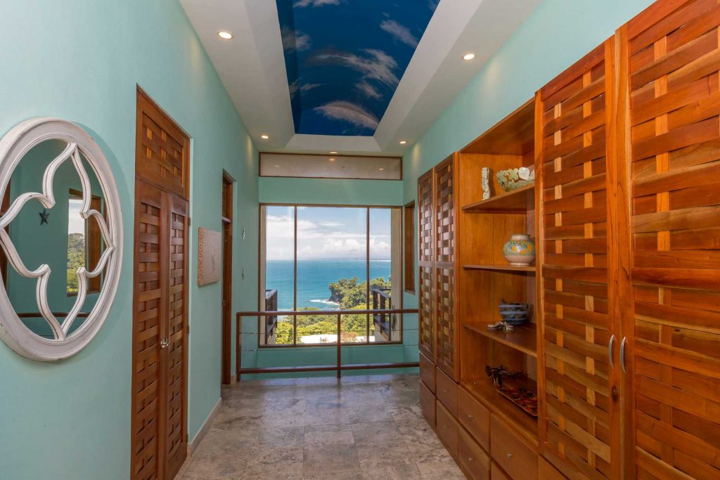 The landing area features wooden shelving and storage, a beautiful painted ceiling, and a spectacular ocean view.