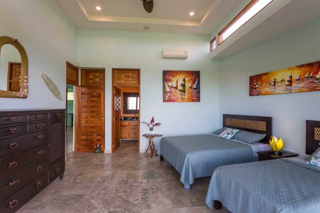 This ocean-view bedroom on the second floor has a queen and twin bed, balcony, ensuite bathroom and air conditioning.