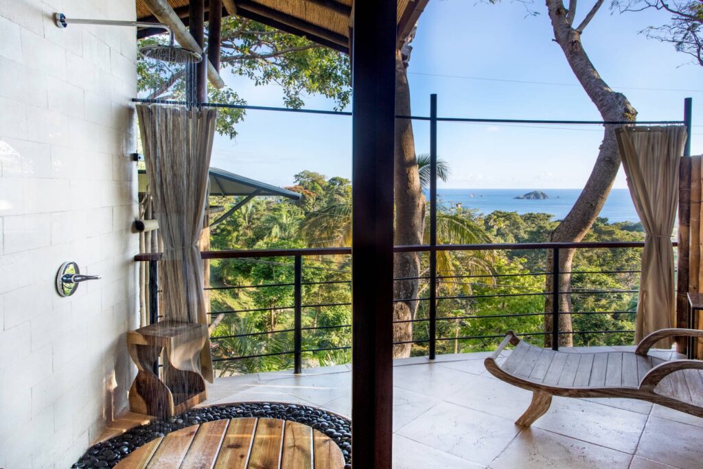A refreshing outdoor shower and terrace where rainforest views and ocean horizons create a calming, nature-immersed experience.