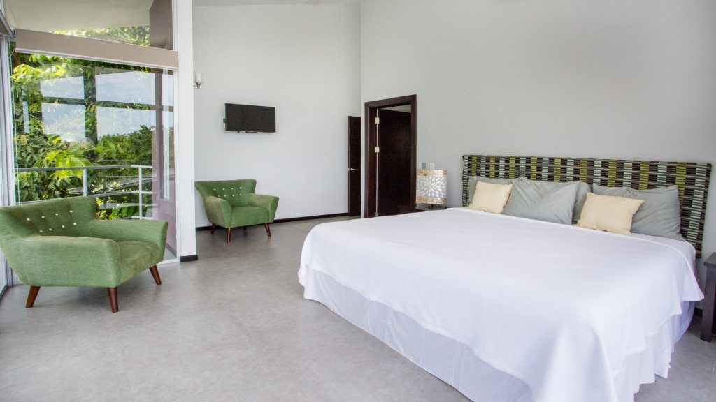 A super-comfortable king bed and retro furnishings highlight the master bedroom at this amazing rental in Manuel Antonio.