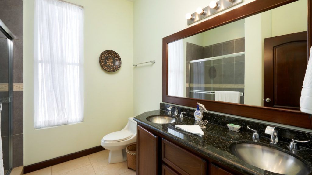 This bathroom features an extra large mirror with double sinks.