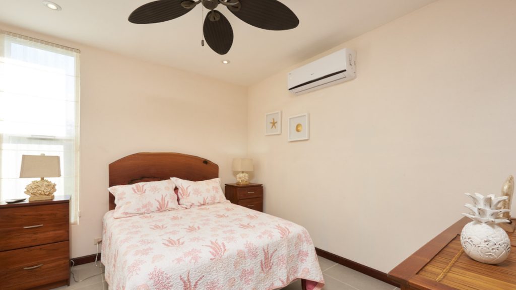A quaint room with a beach like atmosphere and double bed.