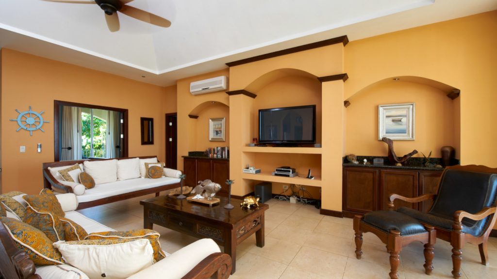 This living room has a flat screen television, lots of seating space, and air-conditioning.