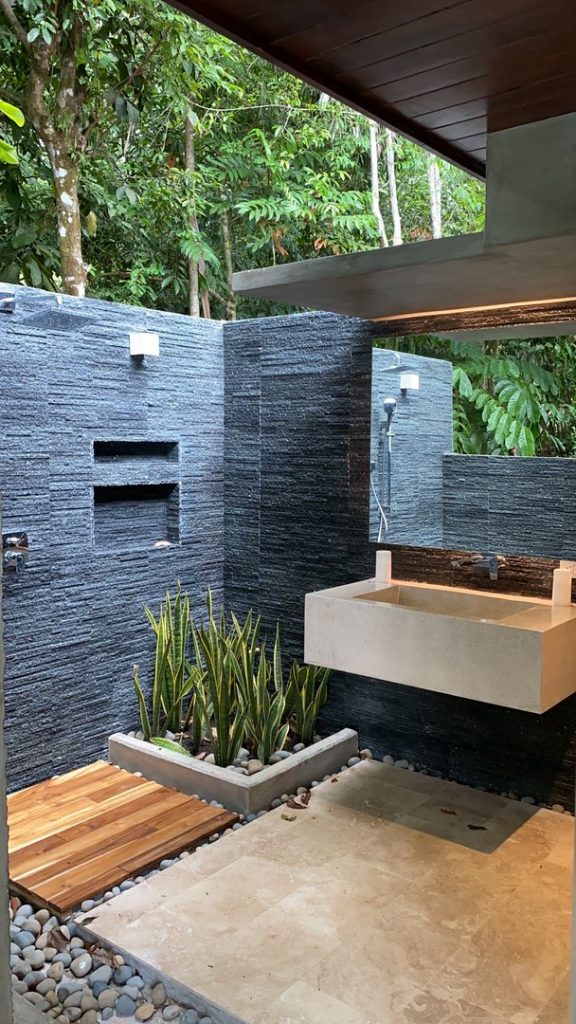 There are marble, slate, stone, and wood features in this outside bathroom.