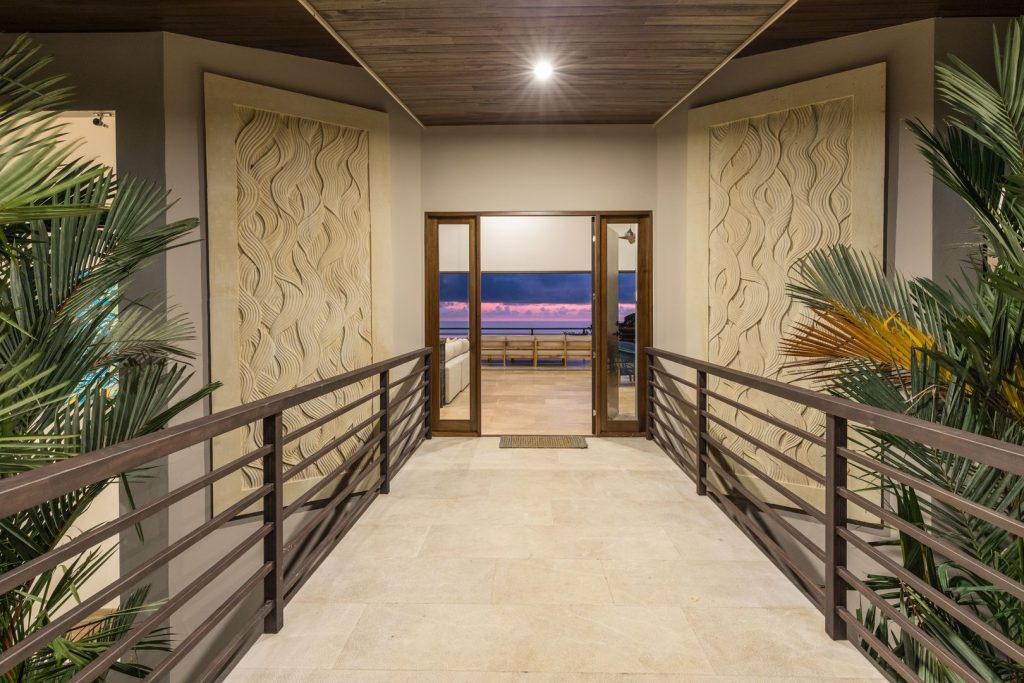Two dramatic hand-carved murals mark the entrance, the breathtaking sunset ocean view between.