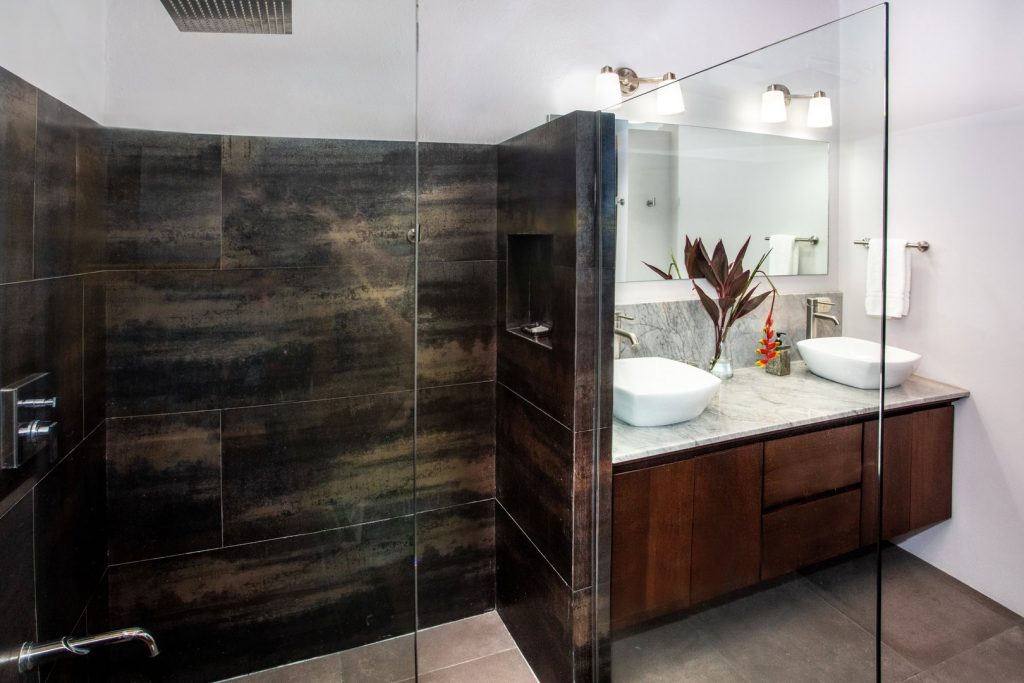 This guest bathroom has his and hers sinks and a stunning designer shower.