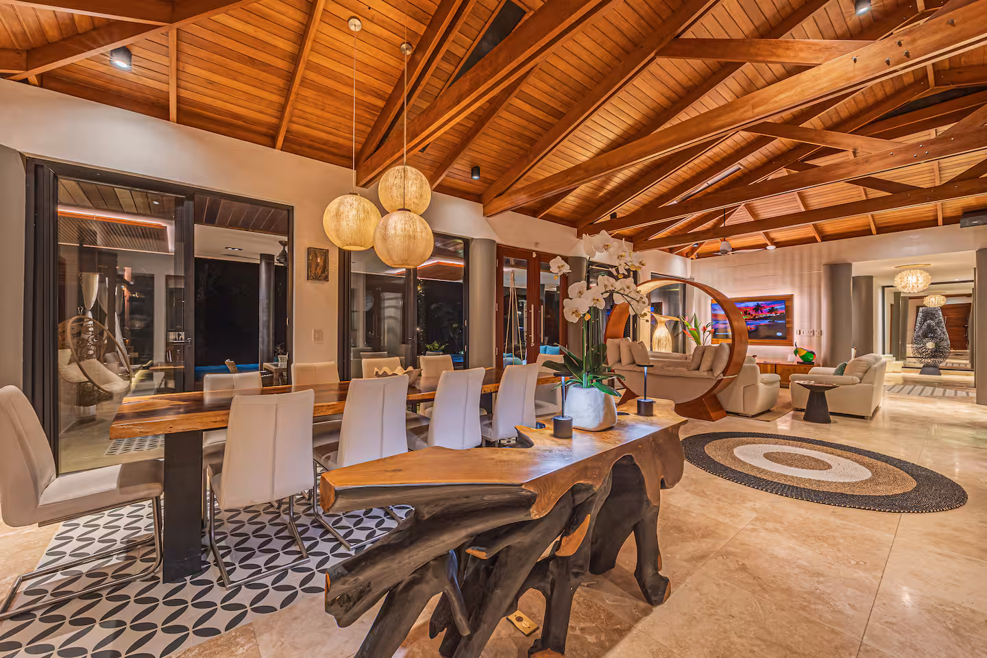 Open dining and living area with wood ceilings, large dining table, and lounge seating in a luxury villa near Dominical, Costa Rica.