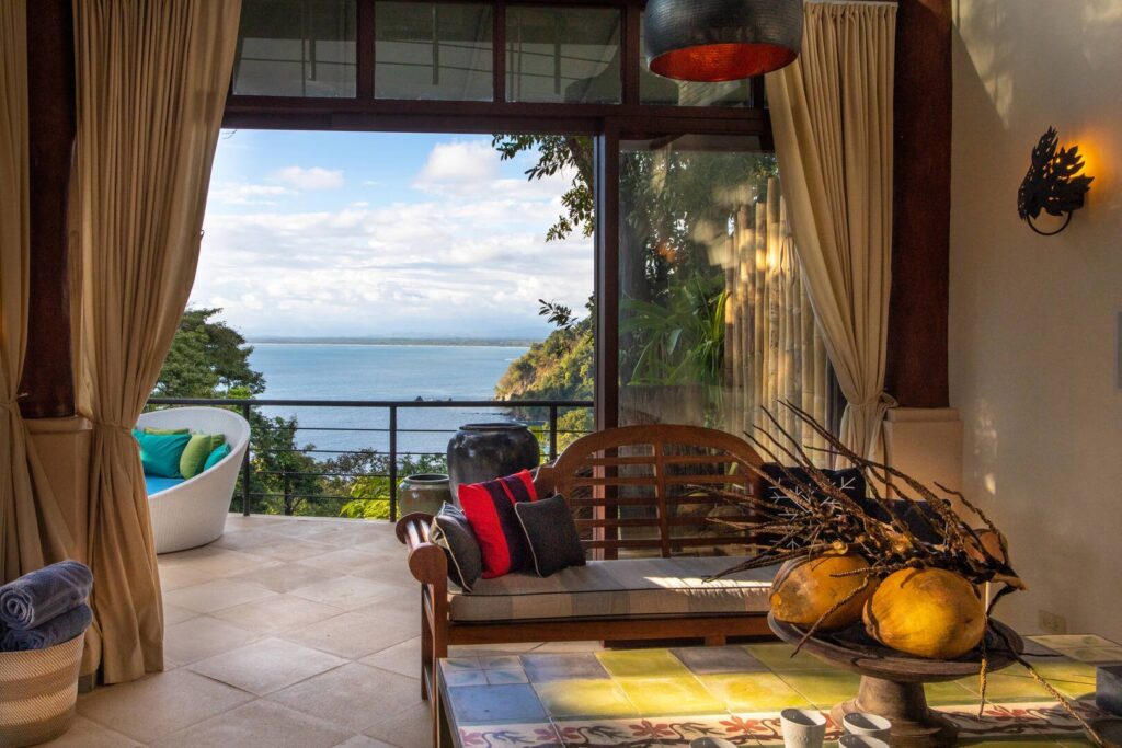 Warm afternoon light settles into the lounge, where soft curtains and open views create a calm, easy flow between indoors and out.
