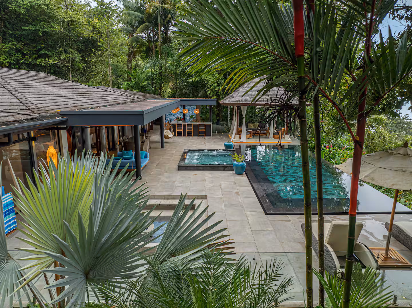 Open-air villa with pool terrace surrounded by tropical jungle.