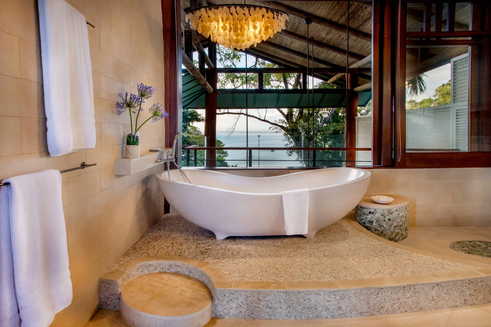 Sculpted soaking tub on stone terrace with ocean and rainforest views in Manuel Antonio