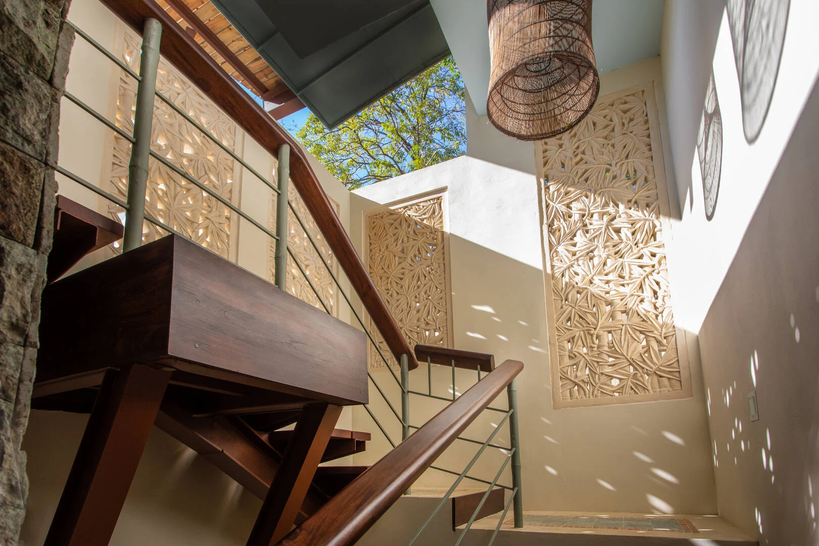 Hand-carved wall panels with wood details and natural light inside a villa in Manuel Antonio