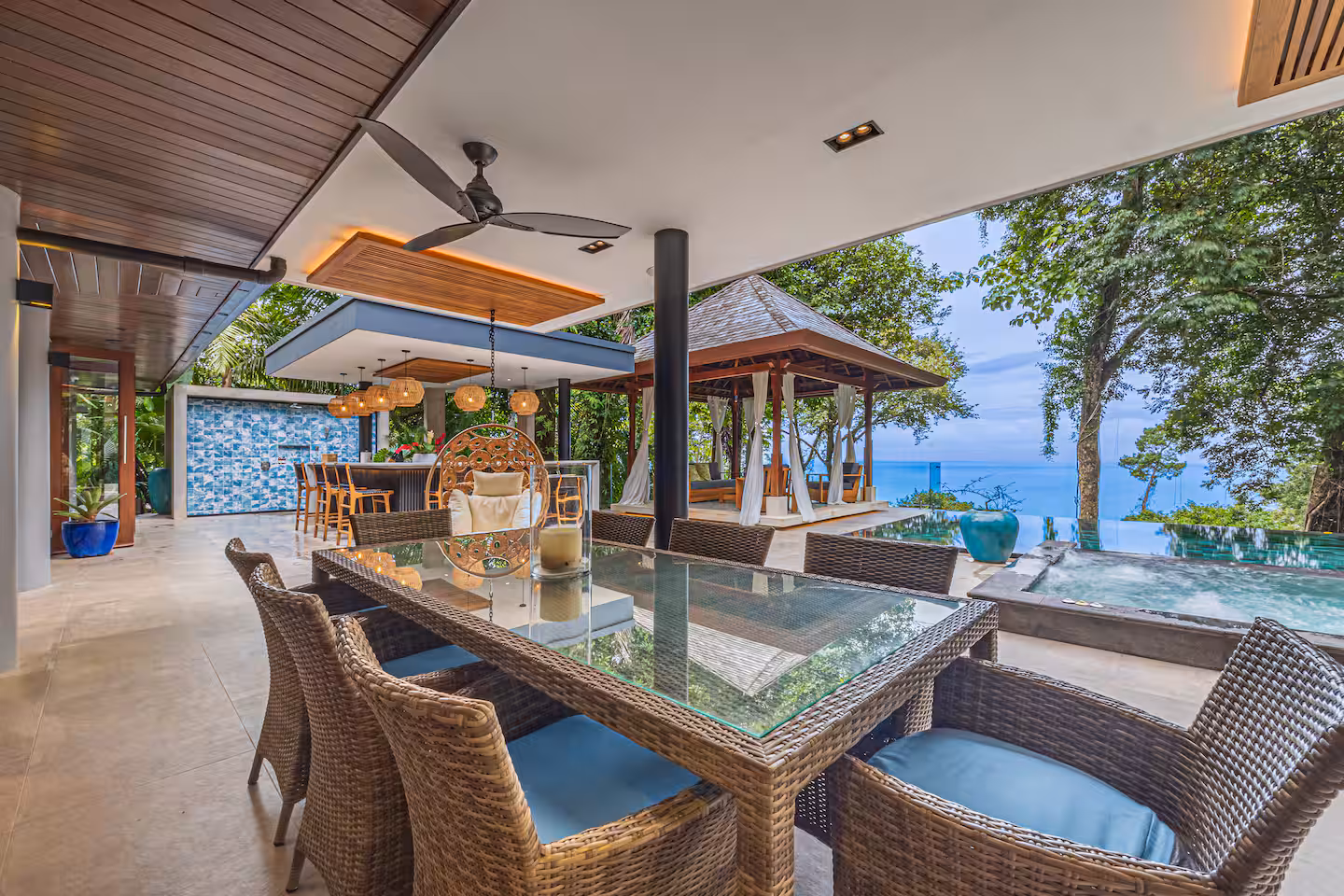 Covered outdoor dining area with pool, lounge seating, and ocean views at a luxury villa near Dominical, Costa Rica.