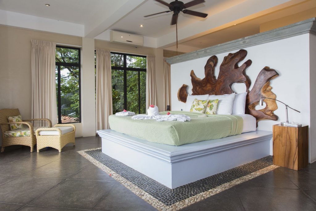 The king bed in the master bedroom faces the ocean with large glass sliding doors and a private balcony. 