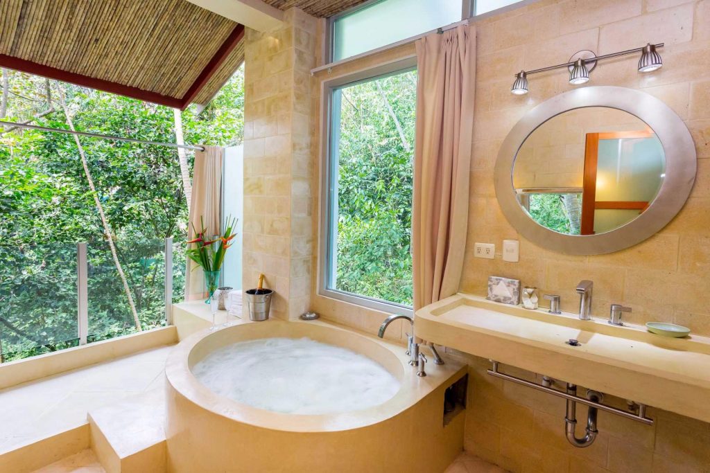 This open-air bathroom has a separate shower and a luxurious tub perfect for a relaxing bubble bath. 
