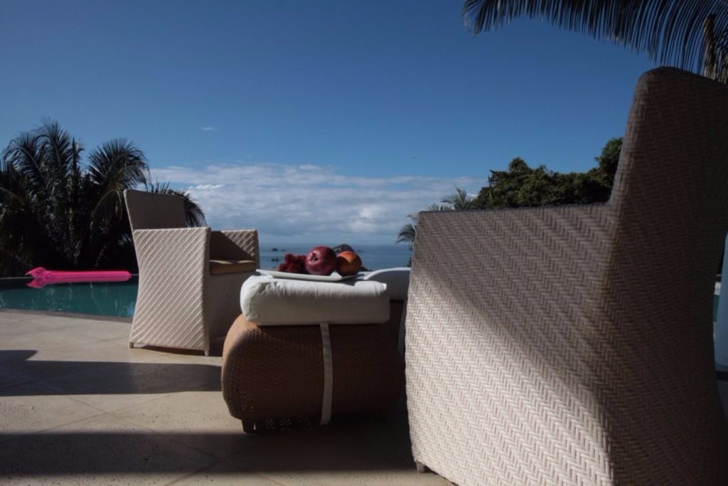 Comfortable wicker furniture on the pool deck allows guests to enjoy the ocean view. 
