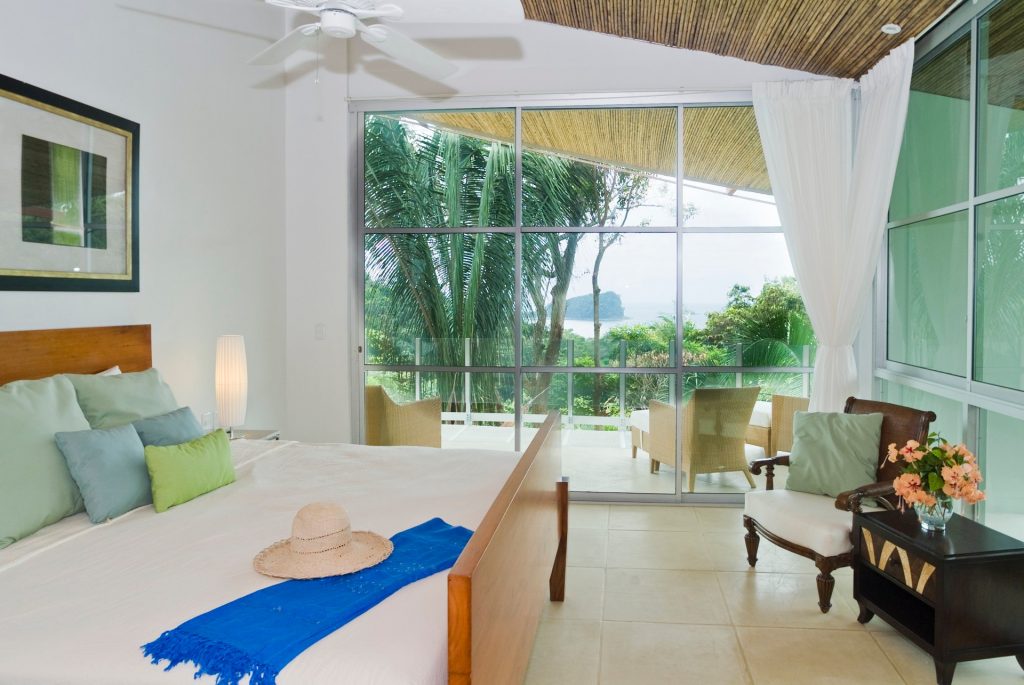 An upper-level bedroom of this one-of-a-kind vacation villa has a fabulous ocean view from the terrace.