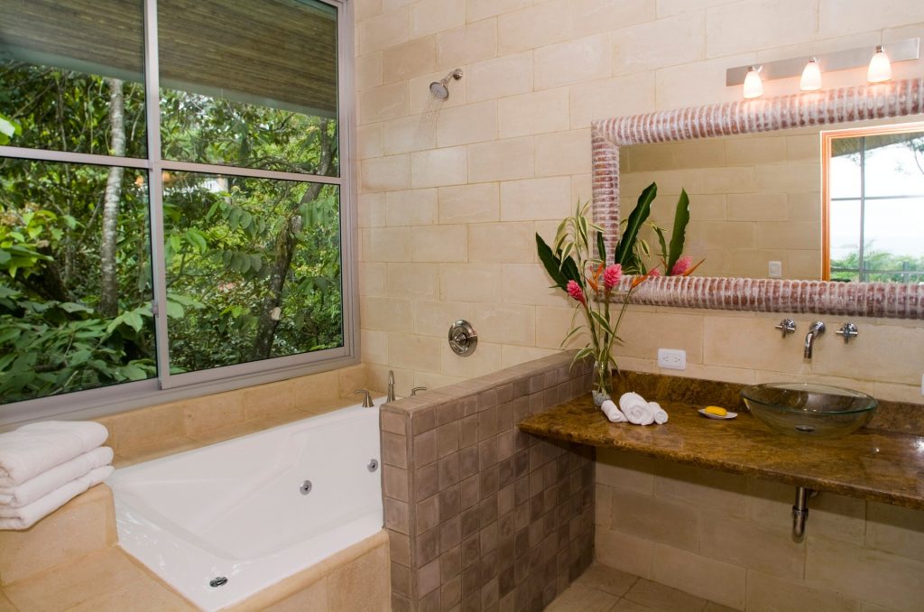 Take in the jungle view while enjoying a refreshing whirlpool bath in this beautifully-designed bathroom. 