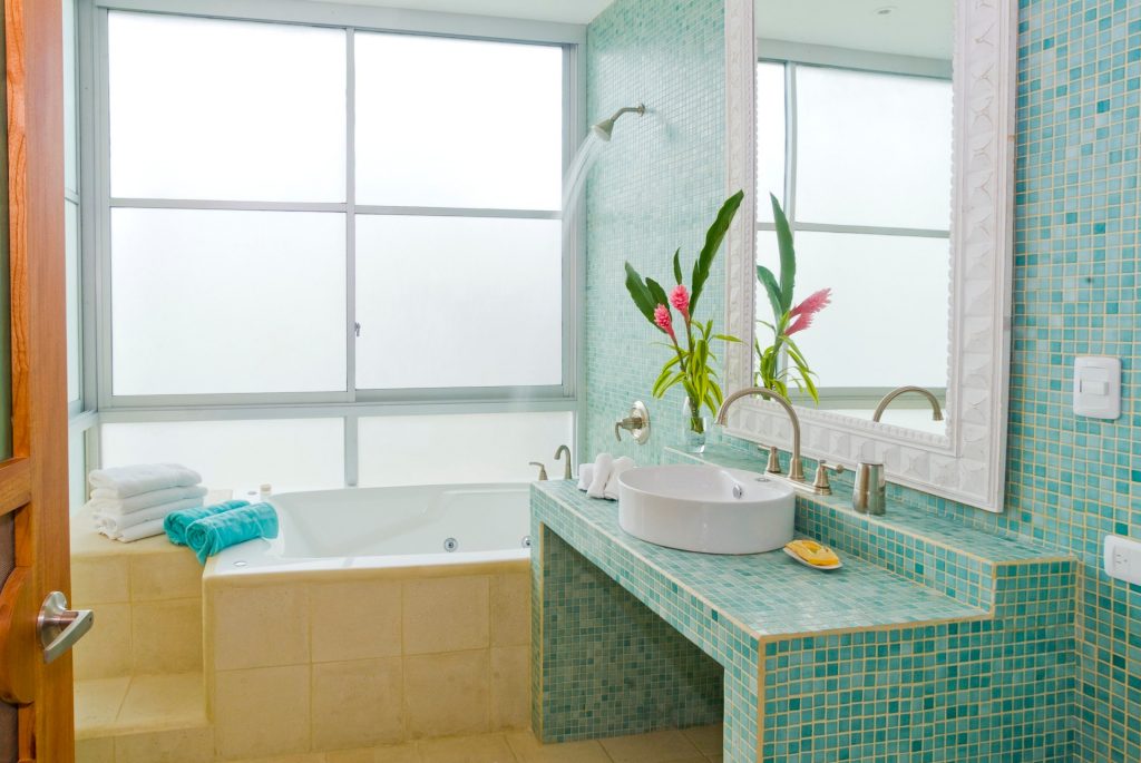 This colorful bathroom with a whirlpool tub is a great example of tile and stone featured throughout this stunning villa.