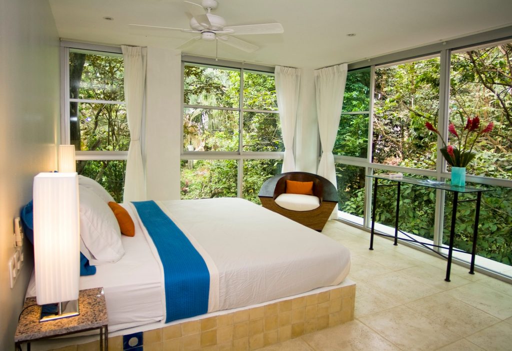 This king bed on a tile platform is encircled by rainforest via floor-to-ceiling windows. A truly magical bedroom.