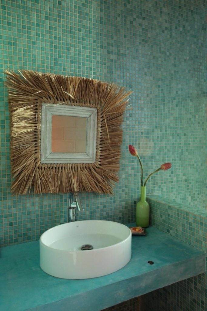 One of the many hand-picked pieces of decor is this straw and distressed wood bathroom mirror. 