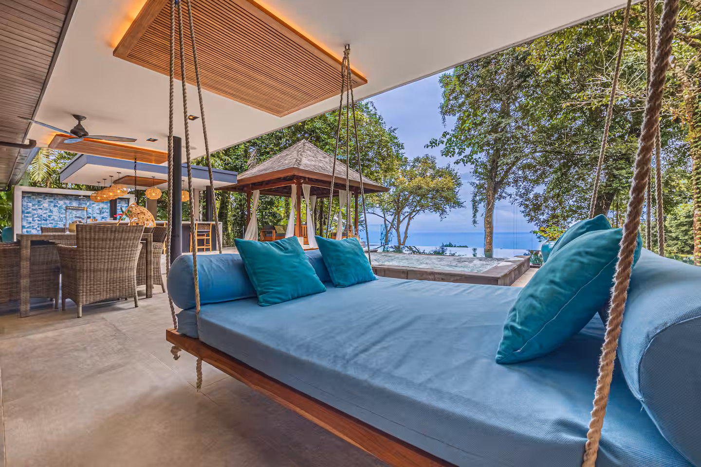 Hanging outdoor lounger beside the pool with jungle and ocean views near Dominical, Costa Rica.
