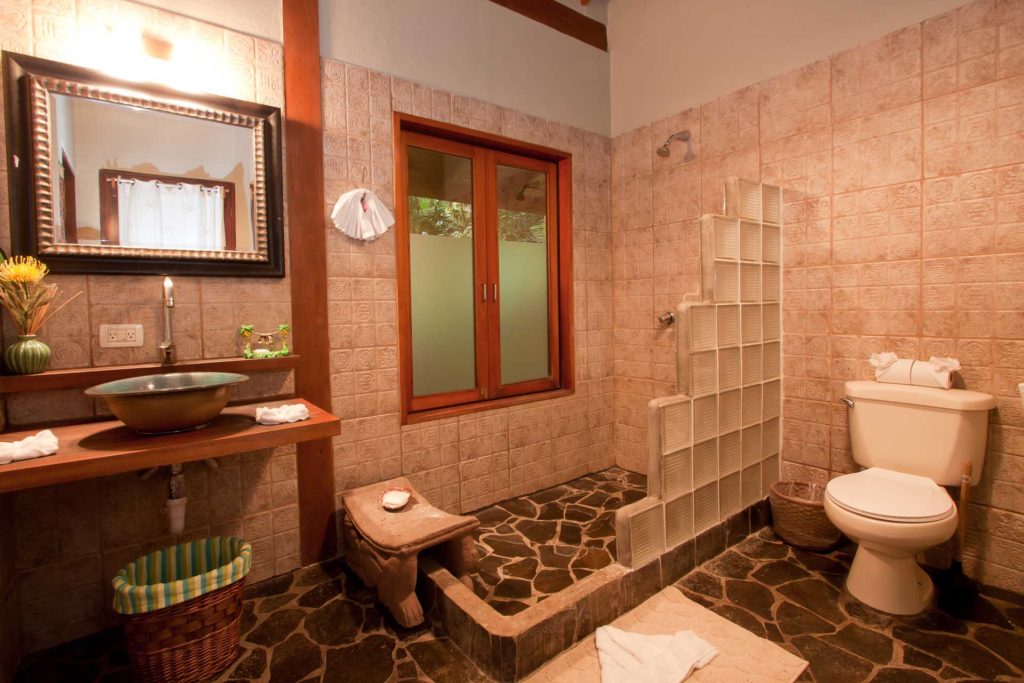 The rustic tiles and stone floor in this bathroom are unique details and great examples of the masterful design of the villa.