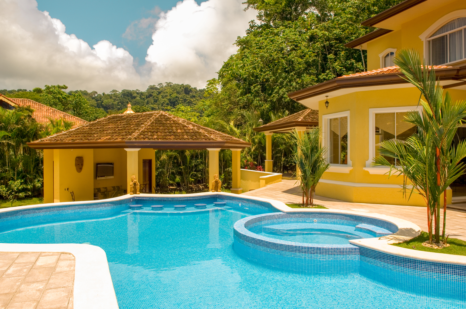 Private villa pool and jacuzzi with covered poolside pavilion and tropical gardens.