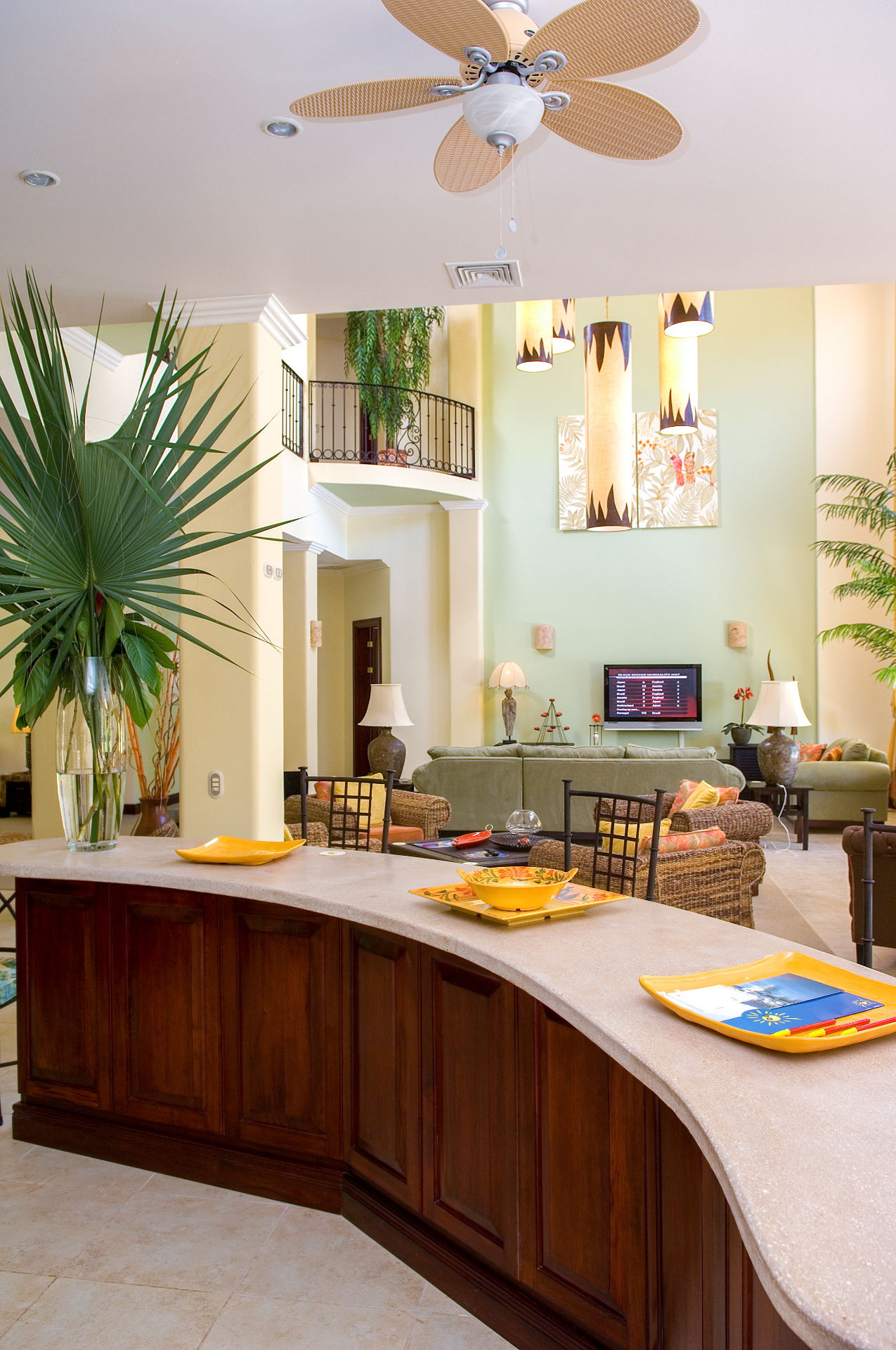 Open kitchen bar overlooking the villa great room with high ceilings, tropical décor, and lounge seating.