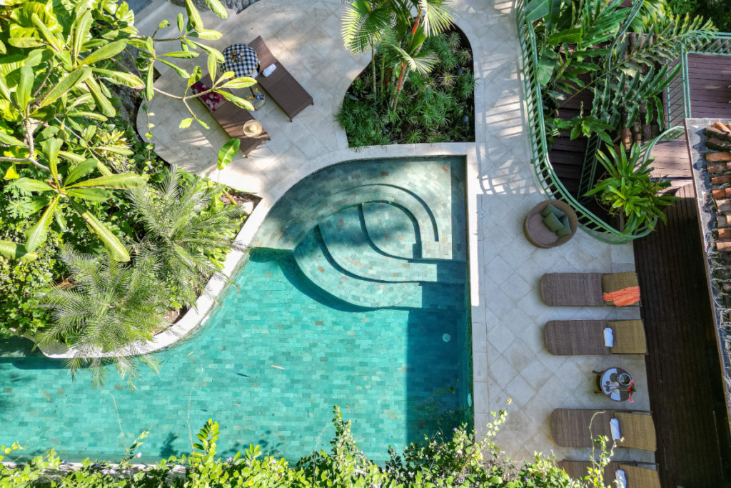 A newly renovated pool and lounge area, set amidst lush tropical gardens.