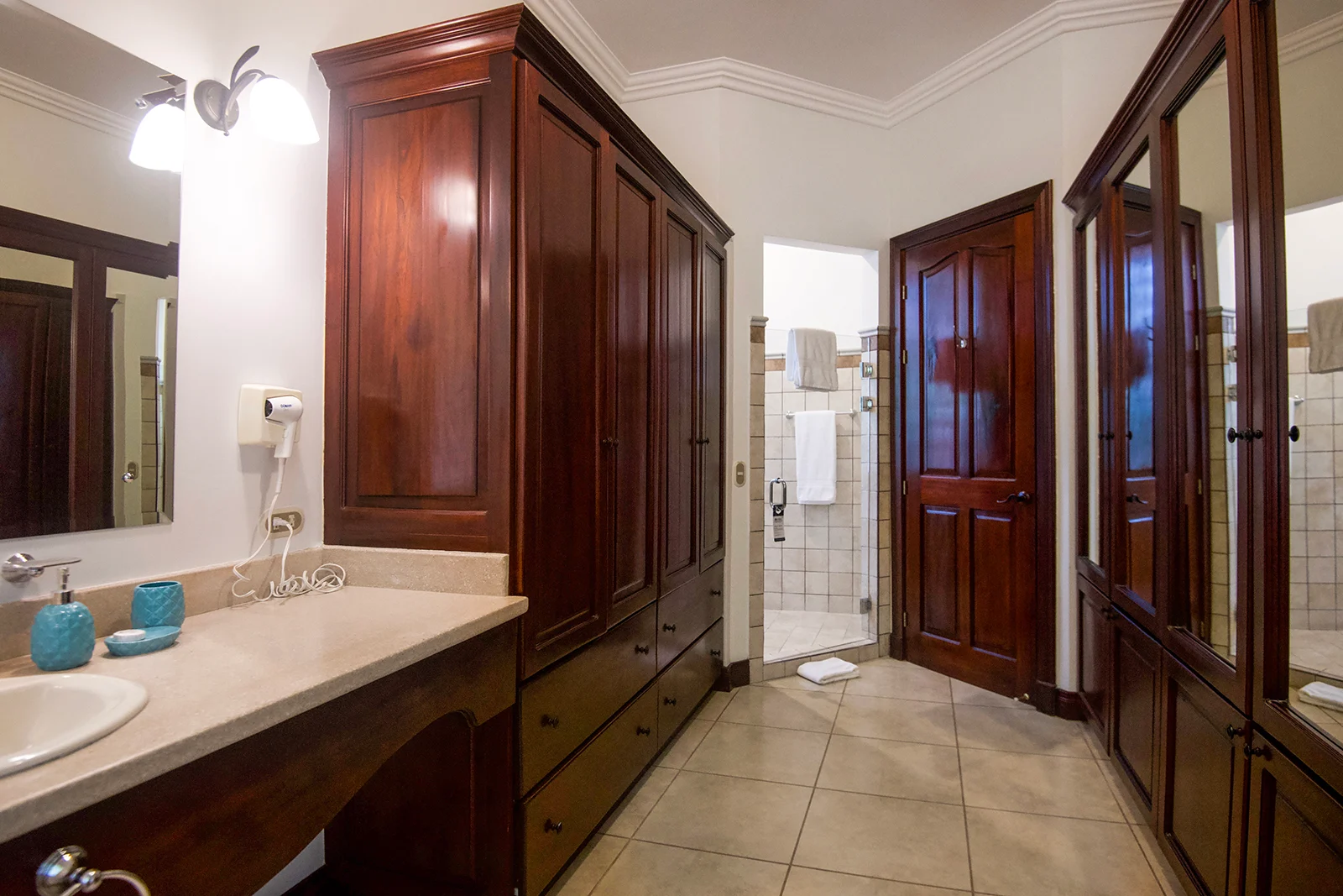 Ensuite bathroom with custom wood cabinetry, double vanity, and walk-in shower.