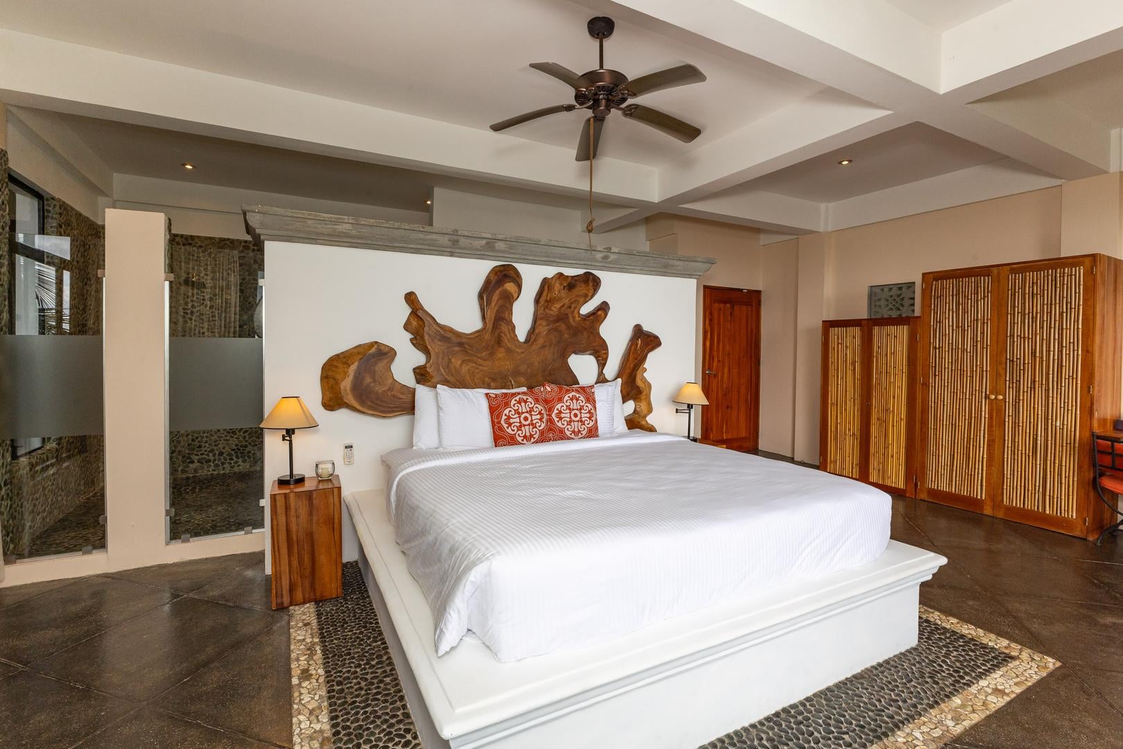 Master bedroom with king bed, wood accents, and ensuite bathroom in Manuel Antonio Costa Rica