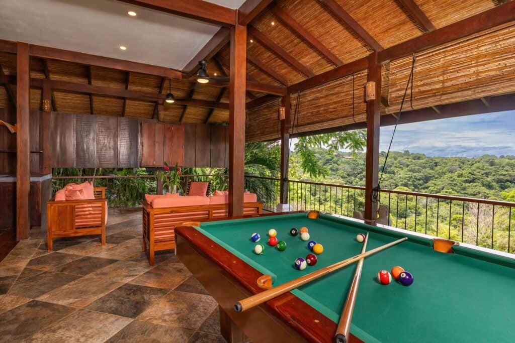 An open-air entertainment space with a pool table, designed for relaxed gatherings within the tropical surroundings.