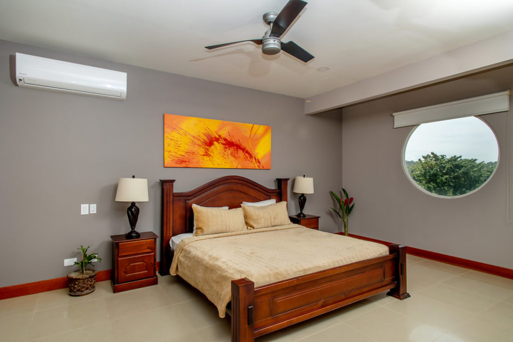 This spacious air-conditioned bedroom features a distinctive circular window.