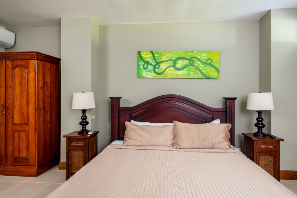 This comfortable bedroom is adorned with beautiful wooden furniture and exotic artwork.