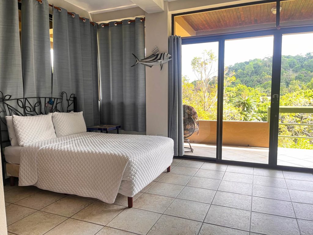 
This bedroom boasts breathtaking views, with huge sliding doors welcoming invigorating tropical breezes, creating a truly serene ambiance.